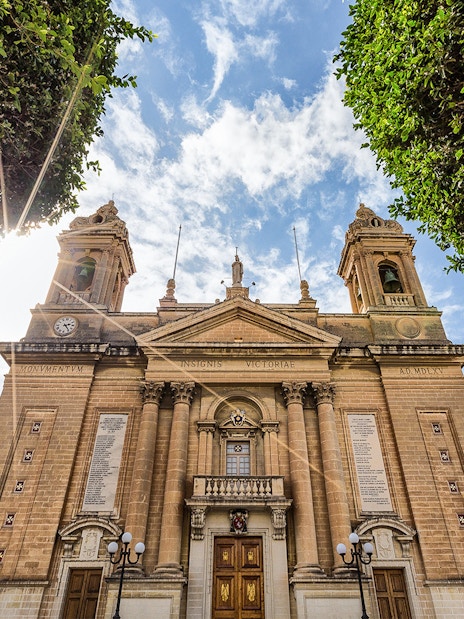 Historic building facade in one of the Three Fortified Cities, Malta, under a sunny sky.