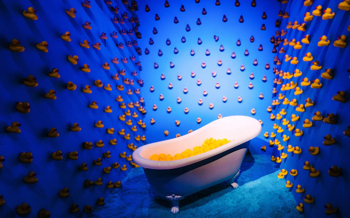 Bathtub filled with rubber ducks in a blue room at Bubble Planet, Cologne.