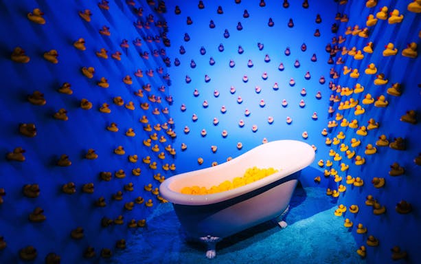 Bathtub filled with rubber ducks in a blue room at Bubble Planet, Cologne.