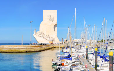 Monument of the Discoveries in Lisbon with marina and sailboats in foreground.