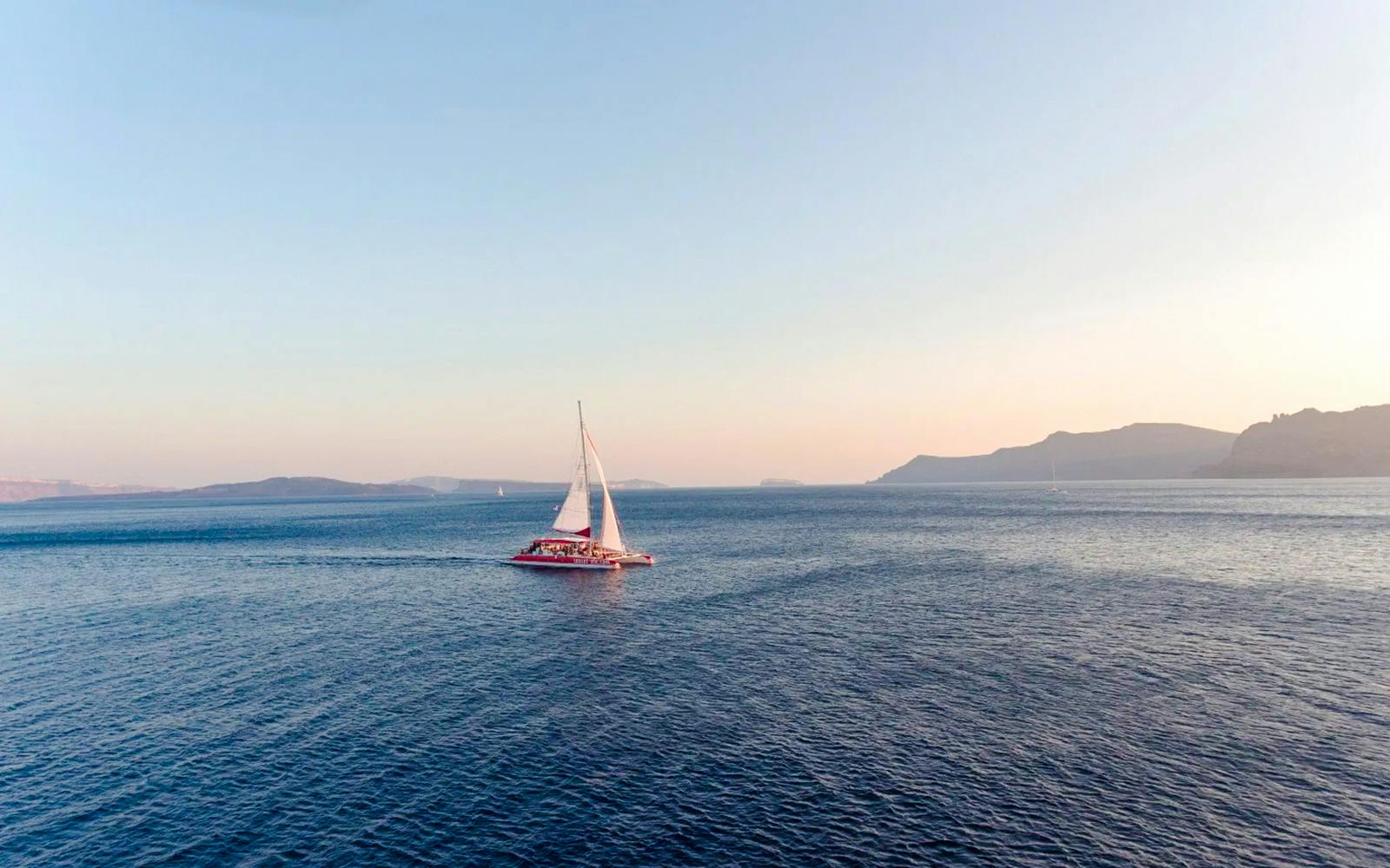 Catamaran sailing on the sea during the Red Cruise near Santorini.