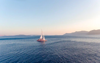 Catamaran sailing on the sea during the Red Cruise near Santorini.