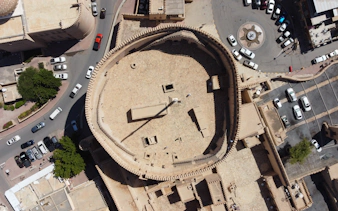 Aerial view of Nizwa Fort's circular courtyard and surrounding streets in Oman.