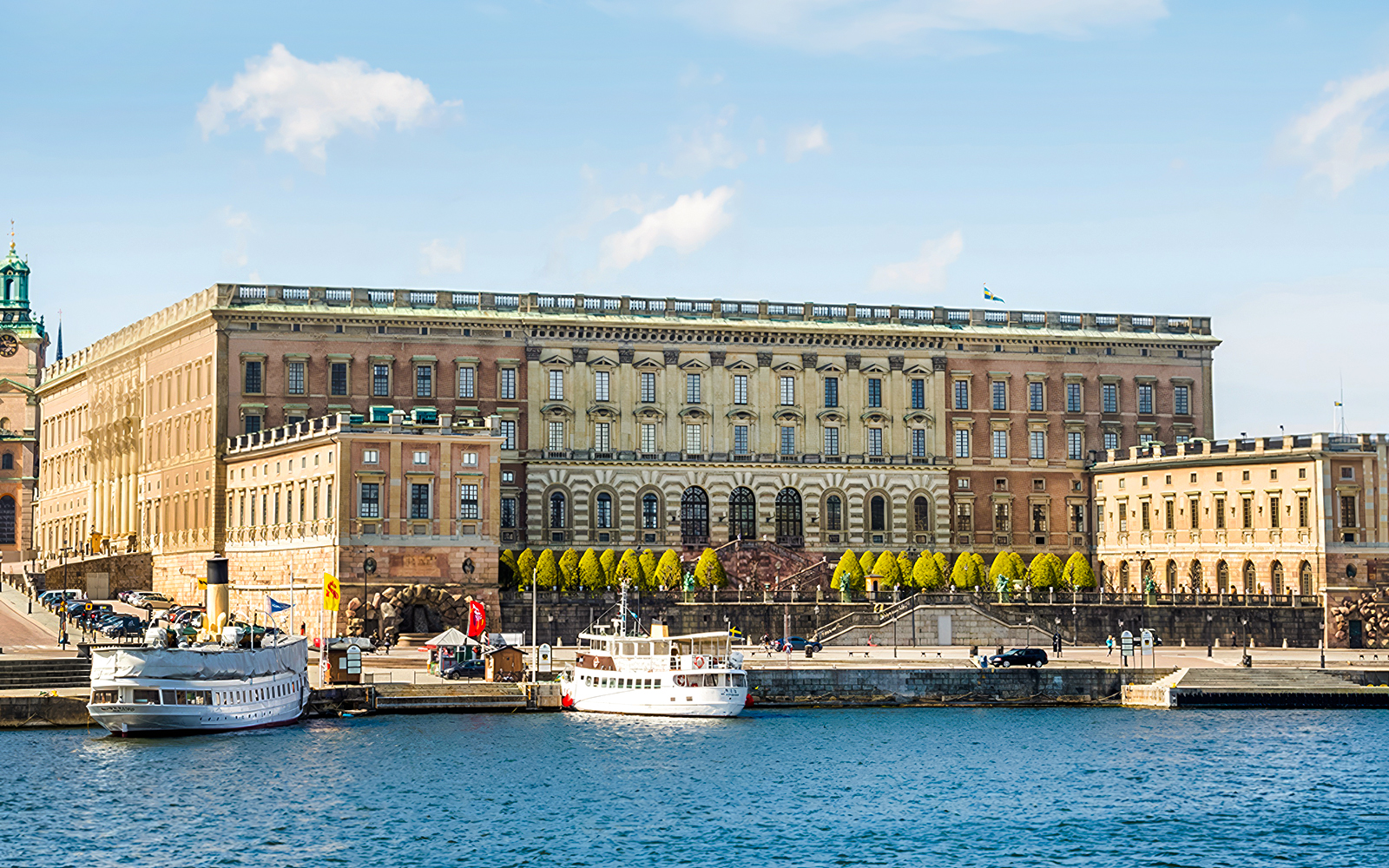 Royal Palace in Stockholm with boats docked at the harbor.