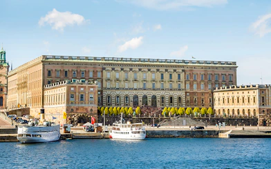 Royal Palace in Stockholm with boats docked at the harbor.