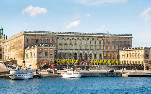 Royal Palace in Stockholm with boats docked at the harbor.