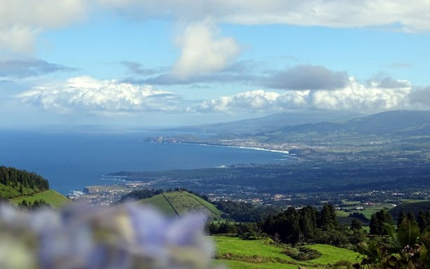 Sete Cidades landscape with ocean view and lush green hills on a half-day van tour.