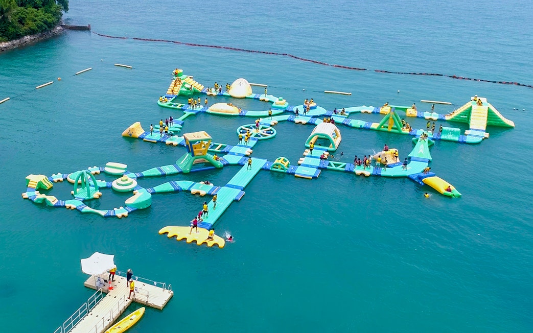 Floating water obstacle course at HydroDash Singapore with participants enjoying activities.