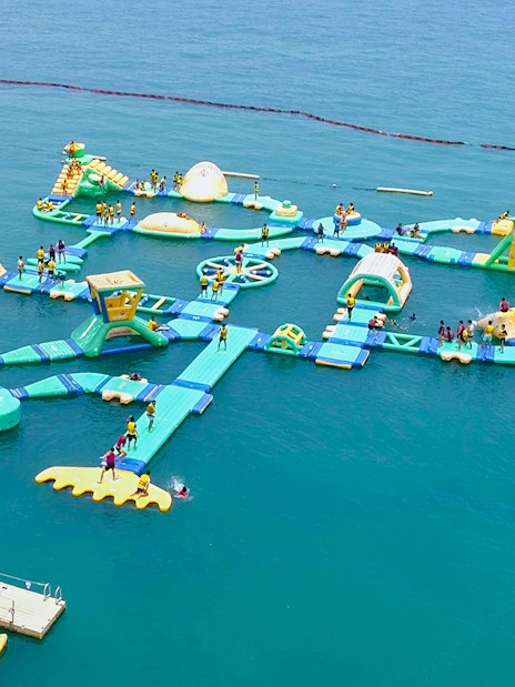 Floating water obstacle course at HydroDash Singapore with participants enjoying activities.