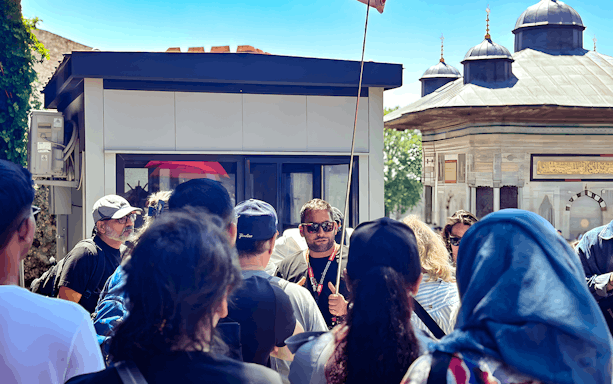 Tour group with guide near Istanbul's Blue Mosque entrance.