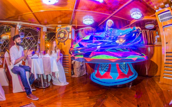 Tanoura dancer performing on Alexandra VIP Dhow Cruise with guests watching.