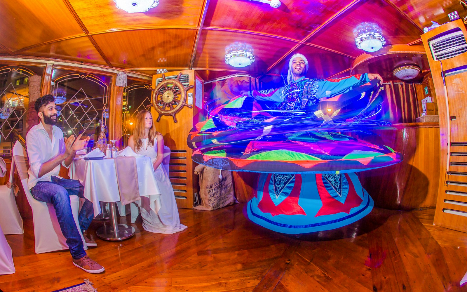 Tanoura dancer performing on Alexandra VIP Dhow Cruise with guests watching.