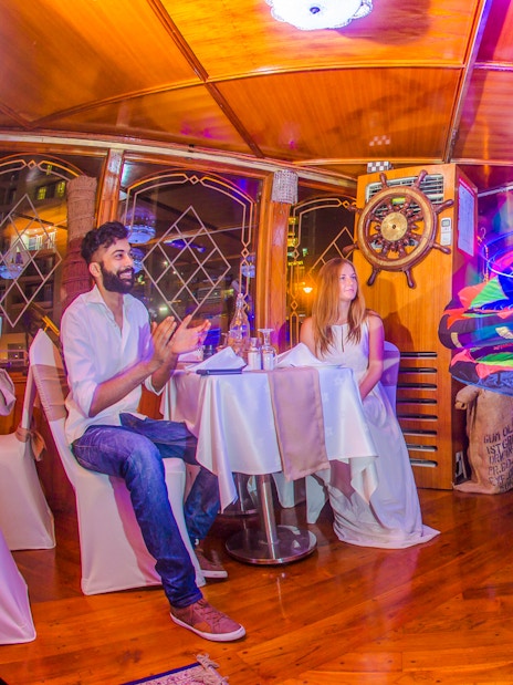 Tanoura dancer performing on Alexandra VIP Dhow Cruise with guests watching.
