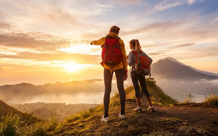 Hikers overlooking sunrise at Mount Batur, Bali.