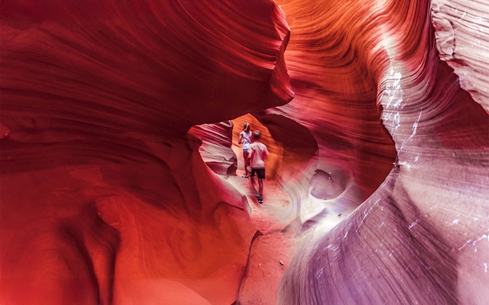 Visitors exploring the vibrant rock formations of Lower Antelope Canyon.