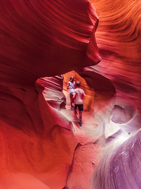 Visitors exploring the vibrant rock formations of Lower Antelope Canyon.