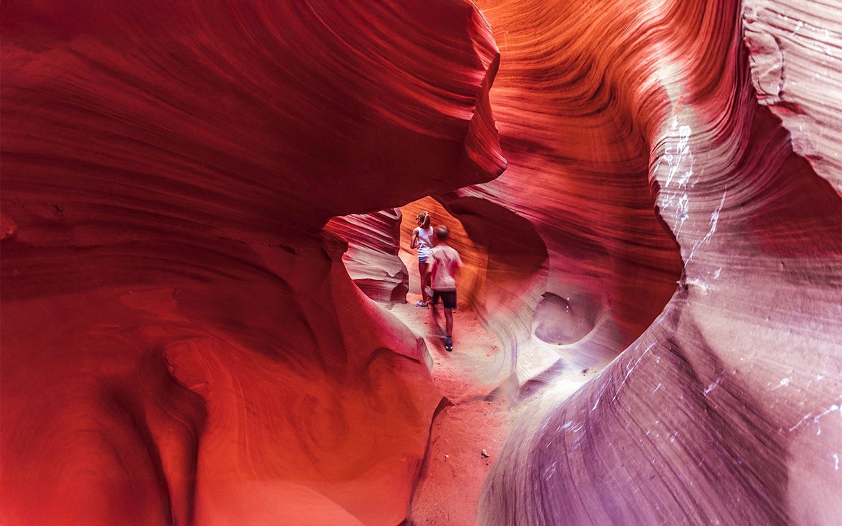 Visitors exploring the vibrant rock formations of Lower Antelope Canyon.