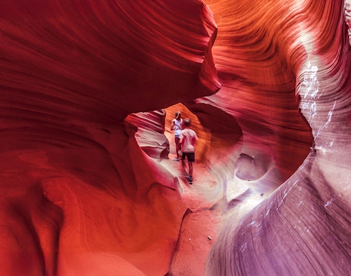 Visitors exploring the vibrant rock formations of Lower Antelope Canyon.