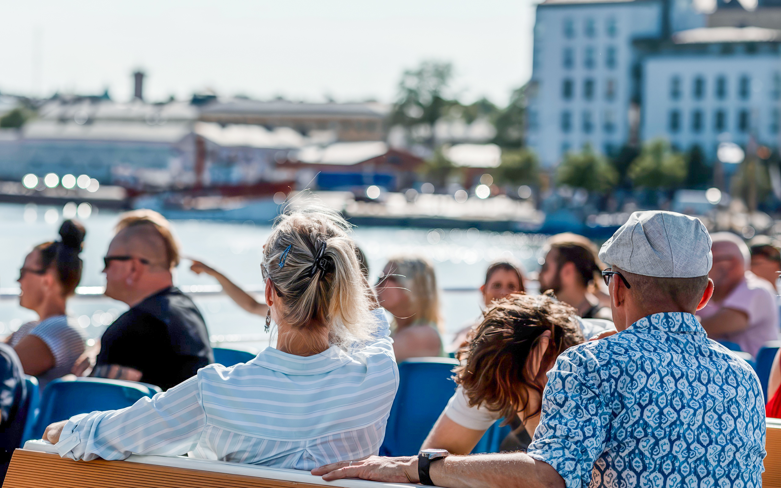 Guests enjoying a ship tour through Helsinki, Finland with cityscape views.