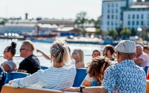 Guests enjoying a ship tour through Helsinki, Finland with cityscape views.