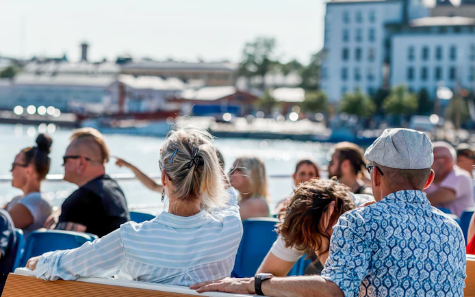 Guests enjoying a ship tour through Helsinki, Finland with cityscape views.