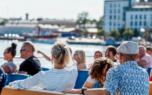 Guests enjoying a ship tour through Helsinki, Finland with cityscape views.