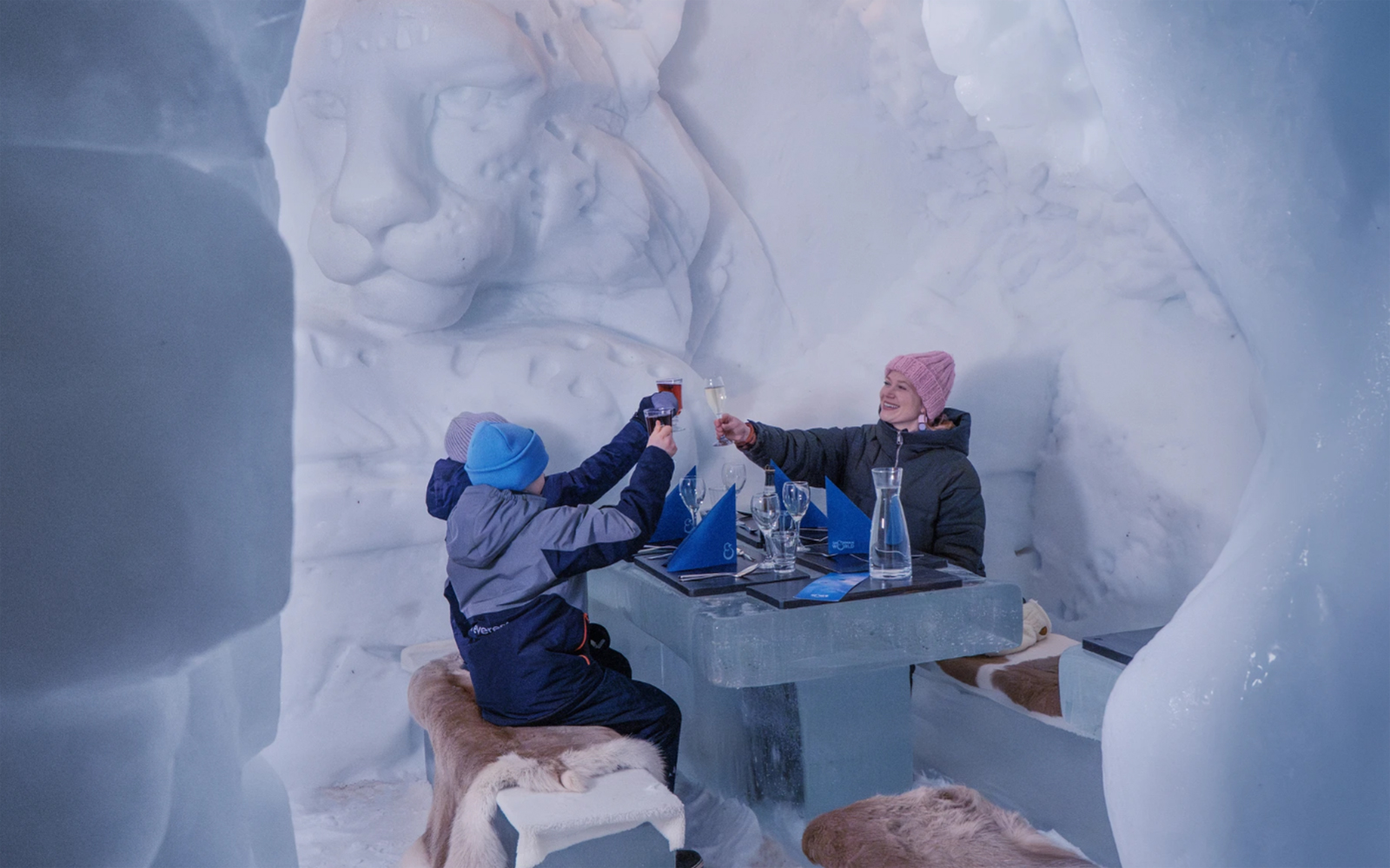 Guests toasting at an ice table in Snowman World, Santa Claus Village.