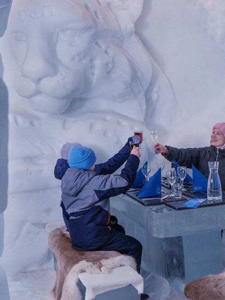 Guests toasting at an ice table in Snowman World, Santa Claus Village.