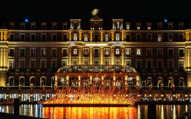 Amsterdam Light Festival installation on water with illuminated building backdrop.
