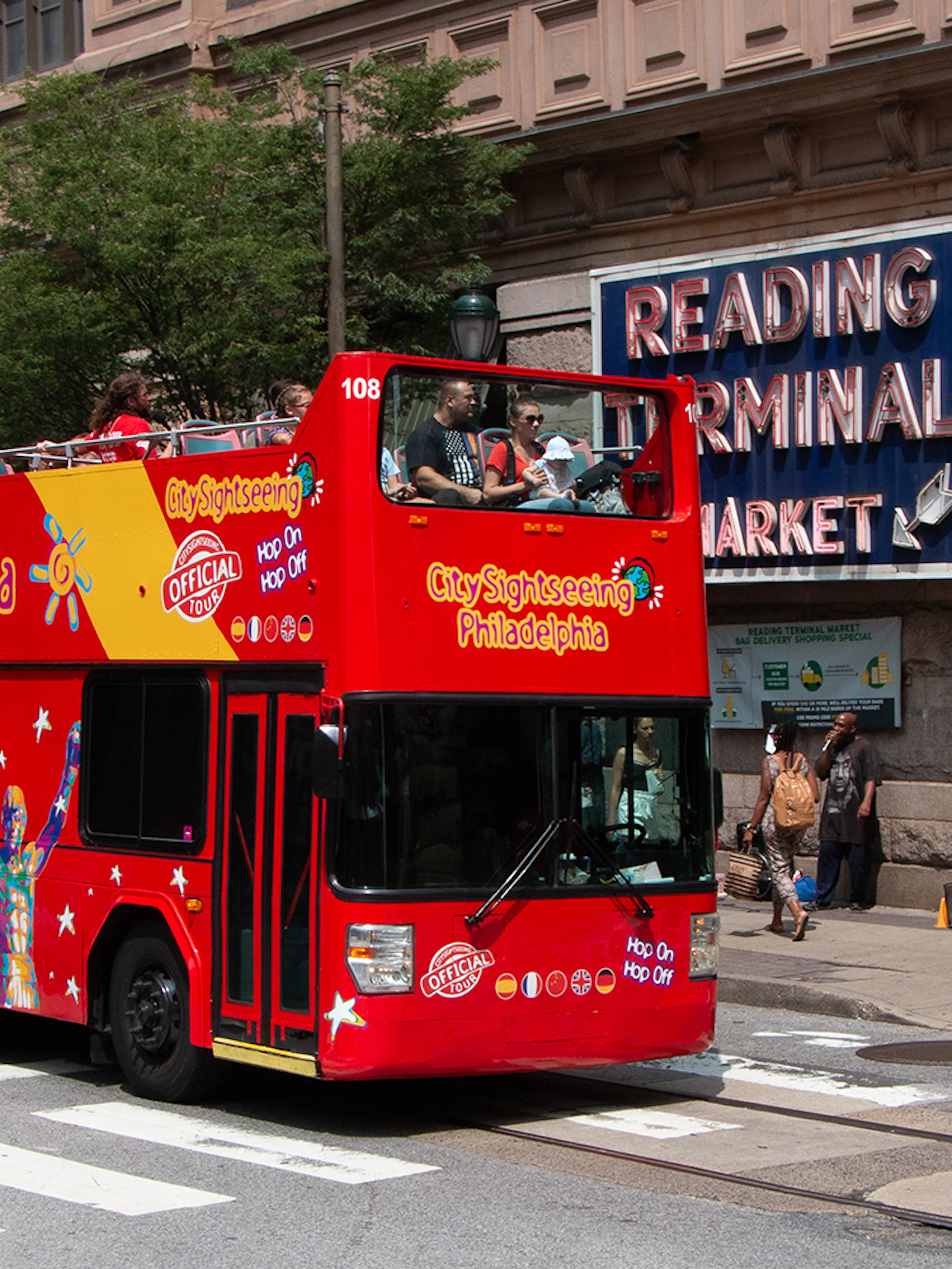 Red double-decker bus on Philadelphia Hop-On-Hop-Off Tour near Reading Terminal Market.