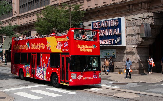 Red double-decker bus on Philadelphia Hop-On-Hop-Off Tour near Reading Terminal Market.