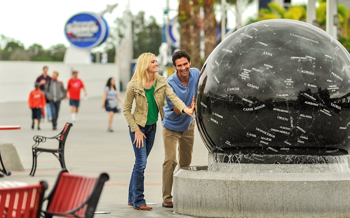 Visitors interact with a constellation globe at Kennedy Space Center, Florida.