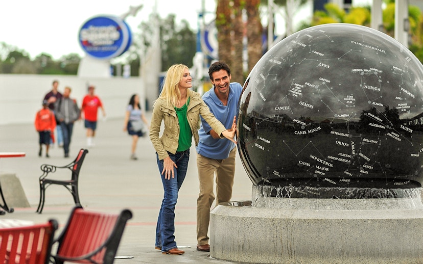 Visitors interact with a constellation globe at Kennedy Space Center, Florida.