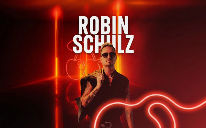 Robin Schulz at Pacha nightclub, Ibiza with neon lights in the background.