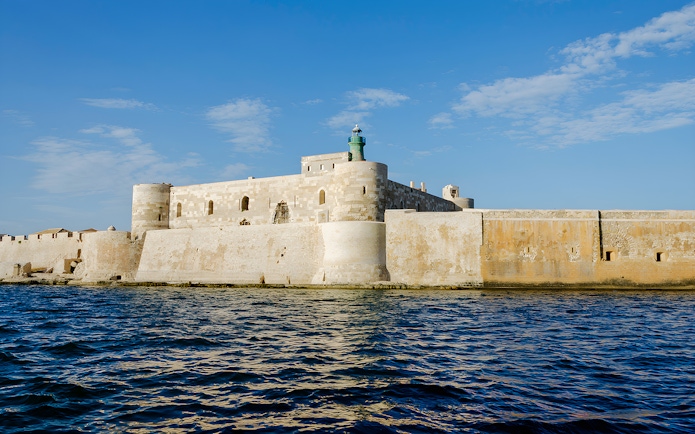 Maniace Castle with lighthouse viewed from the sea in Syracuse, Sicily.