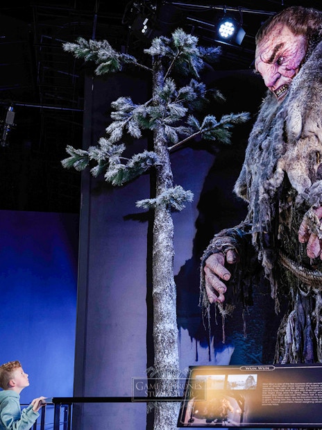 Giant figure display at Game of Thrones Studio Tour with visitor observing.