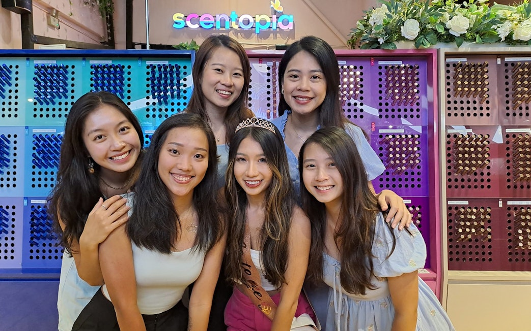 Visitors enjoying Scentopia Sentosa with colorful perfume displays in the background.