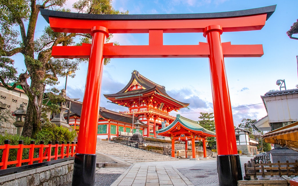 Fushimi Inari Taisha Shrine entrance with red torii gate on Kyoto guided day trip.