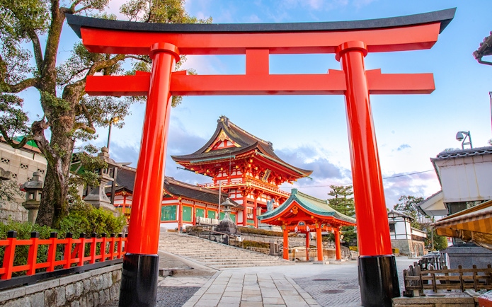 Fushimi Inari Taisha Shrine entrance with red torii gate on Kyoto guided day trip.