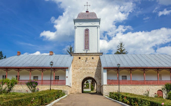Ciolanu Monastery entrance with stone archway and tower, Romania.