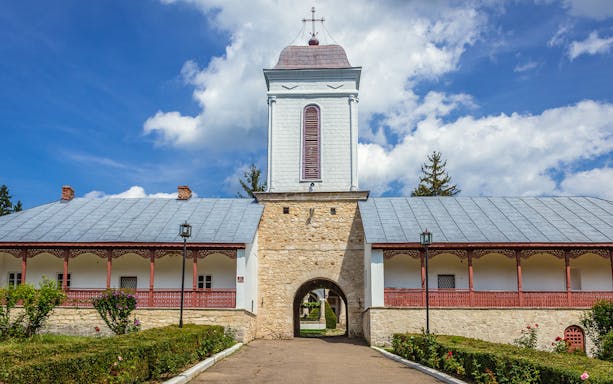 Ciolanu Monastery entrance with stone archway and tower, Romania.