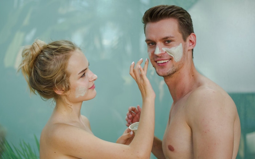 Couple applying face masks in the rainforest sauna at Therme Bucharest.