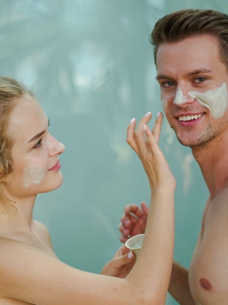 Couple applying face masks in the rainforest sauna at Therme Bucharest.