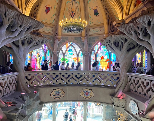 Sleeping Beauty's Castle at Disneyland Paris with vibrant blue turrets and stone archway.