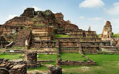 Ayutthaya temple ruins with ancient brick structures under a blue sky, Thailand.