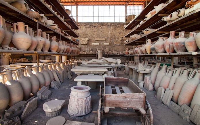 Ancient pottery and artifacts in a storage room at Pompeii archaeological site.