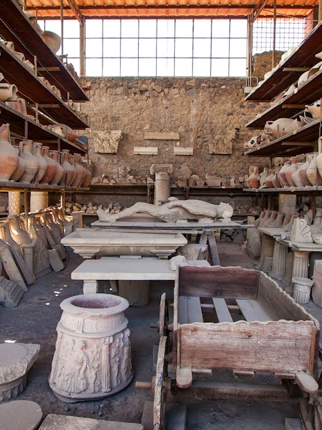 Ancient pottery and artifacts in a storage room at Pompeii archaeological site.