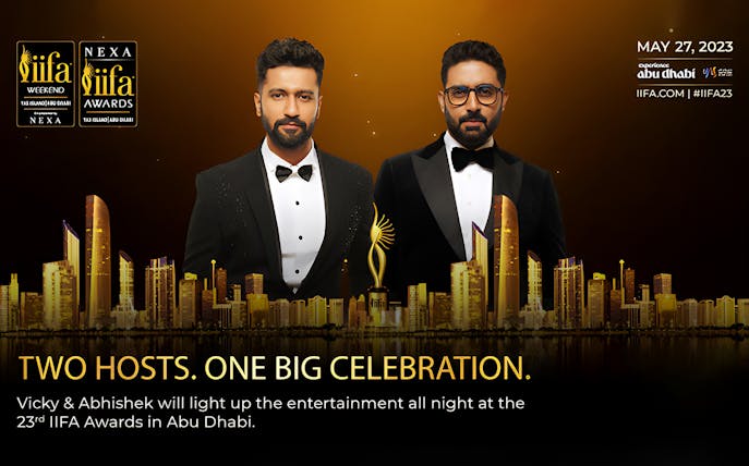 Two hosts at the 23rd IIFA Awards 2023 in Abu Dhabi with city skyline.