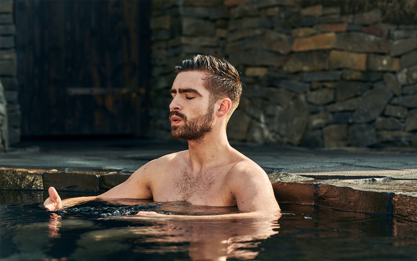 Man relaxing in geothermal pool at Sky Lagoon Saman Pass.