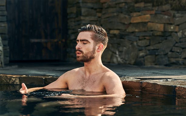 Man relaxing in geothermal pool at Sky Lagoon Saman Pass.